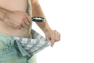 Un uomo guarda il suo pene e vuole aumentarne le dimensioni